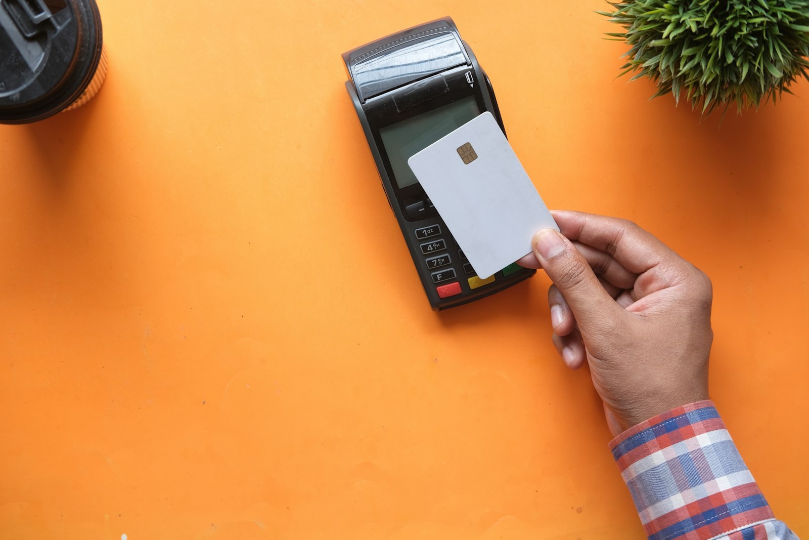 A hand tapping a card on a card reader.