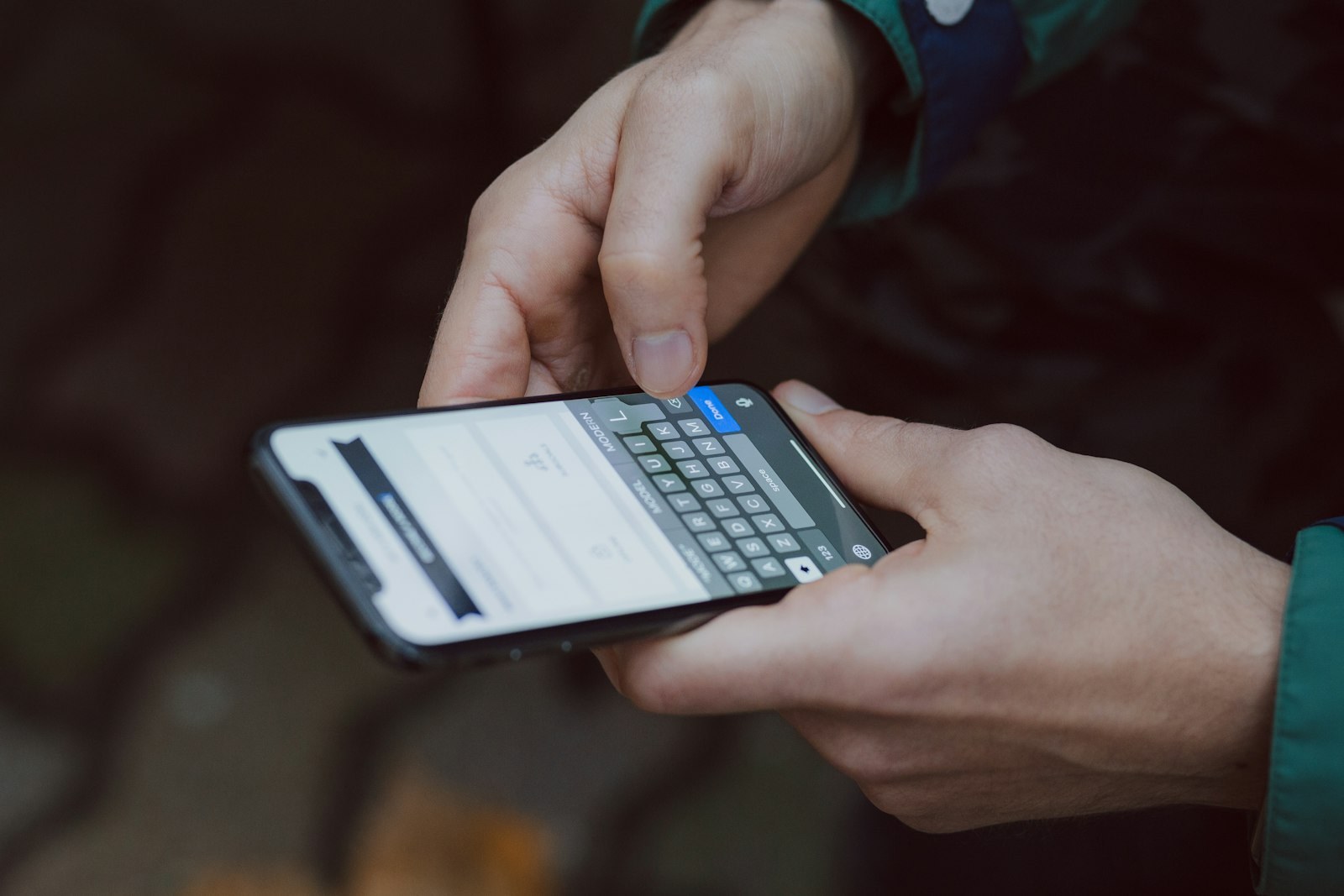 Hands typing on a smartphone.