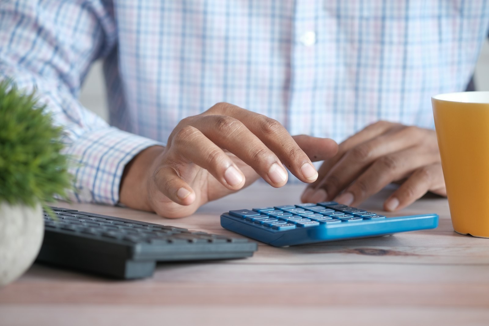 A man working out figures on a calculator at a desk.
