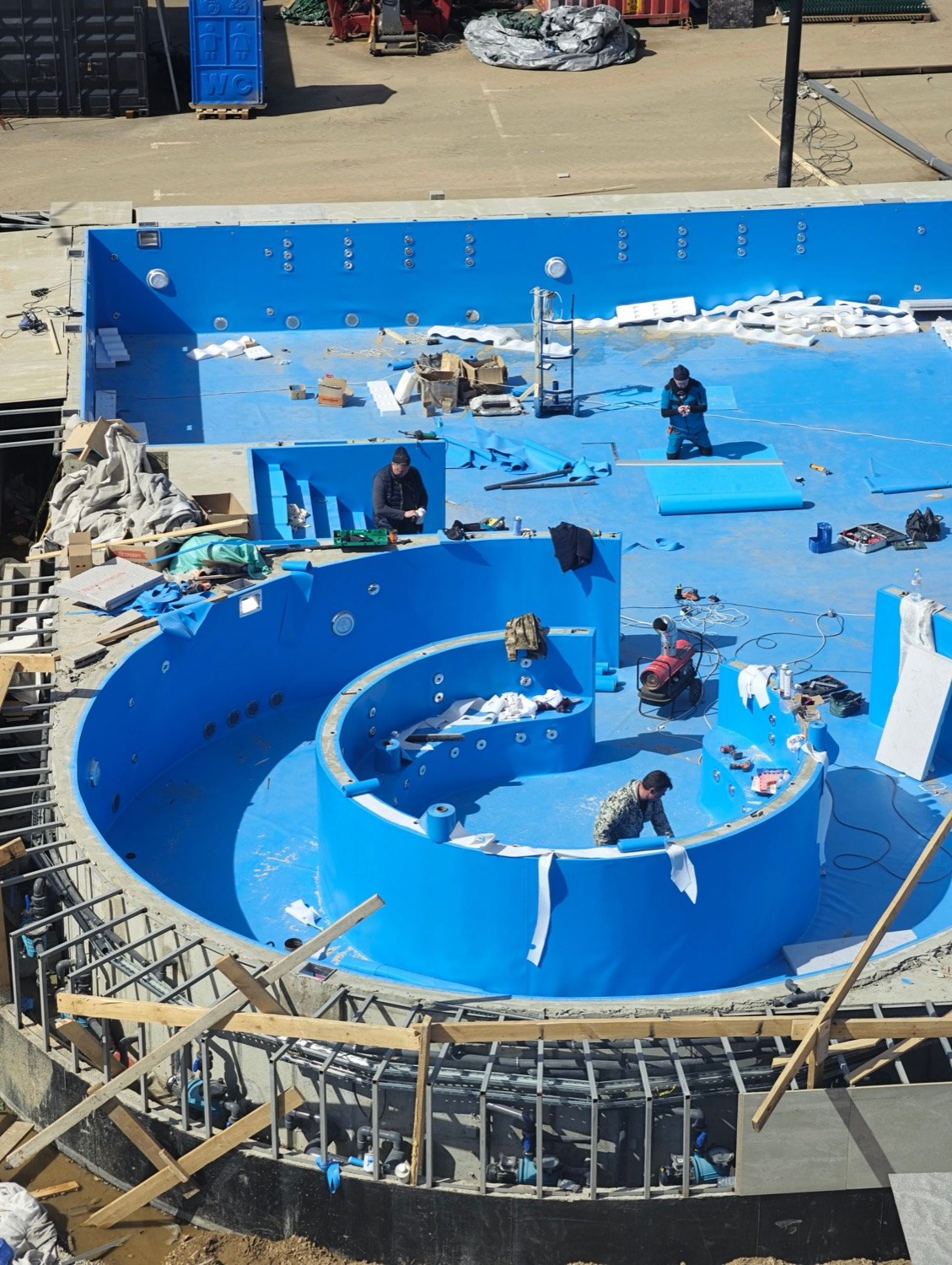 A crew at work on a pool under construction.