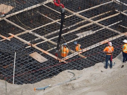 A crew tying the steel for a pool shell, seen from above.