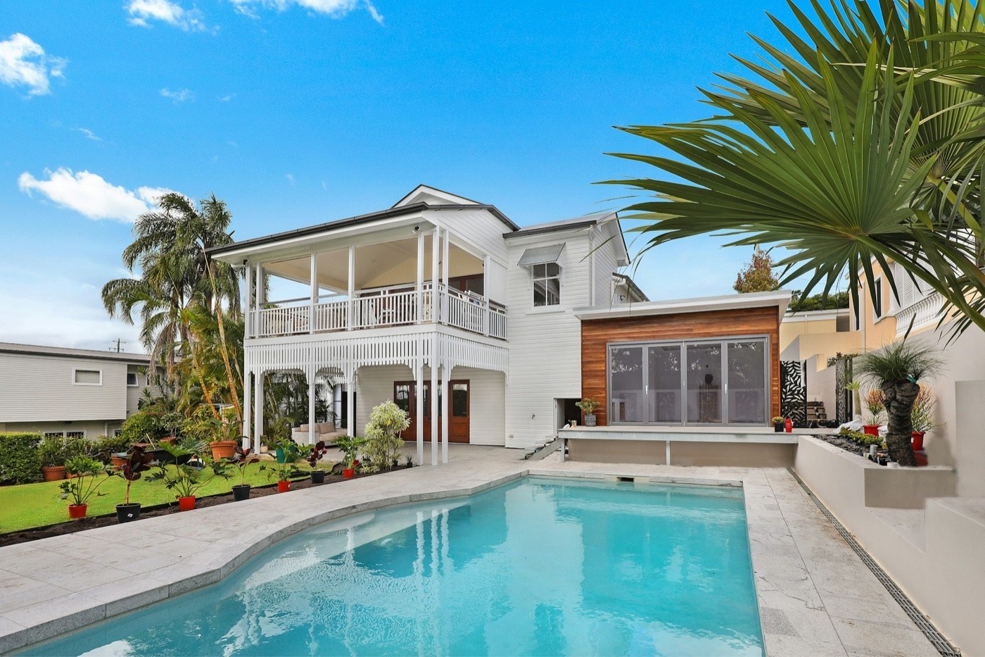 A white house with a pool in the backyard.
