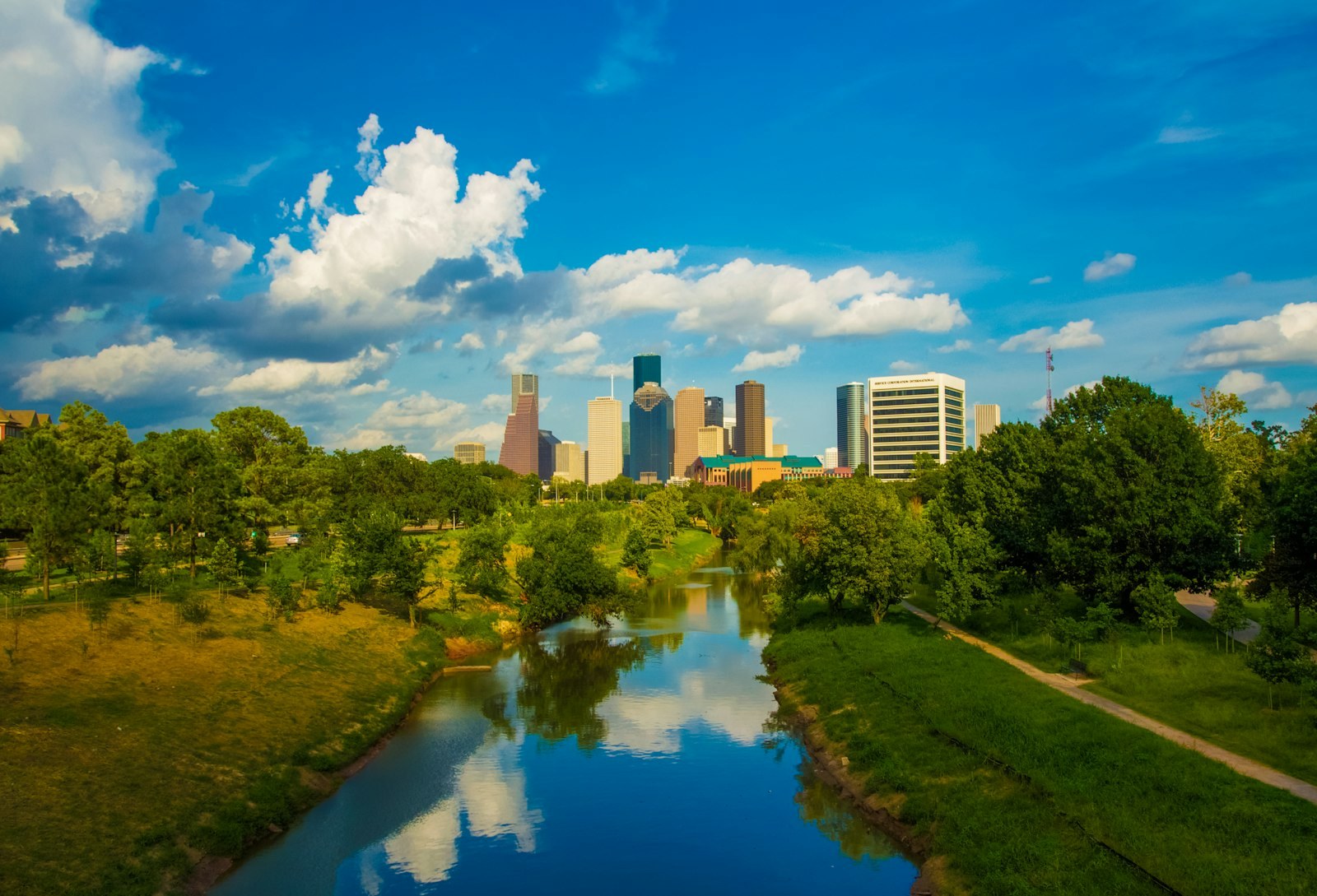 Downtown Houston's skyline beyond the green banks of Buffalo Bayou.