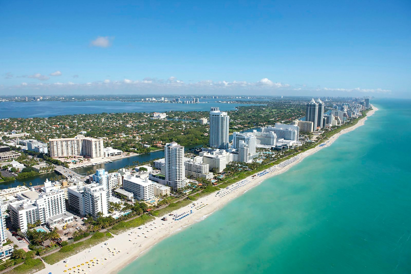 Miami Beach from the air: hotel towers along a turquoise shoreline.